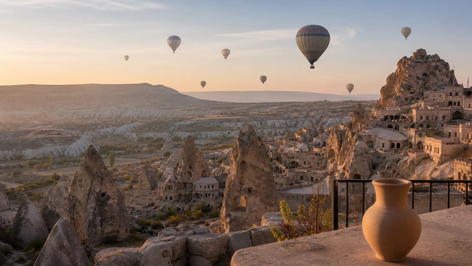 Kapadokya peribacaları üzerinde gün doğumunda yükselen balonlar ve Avanos çömleği