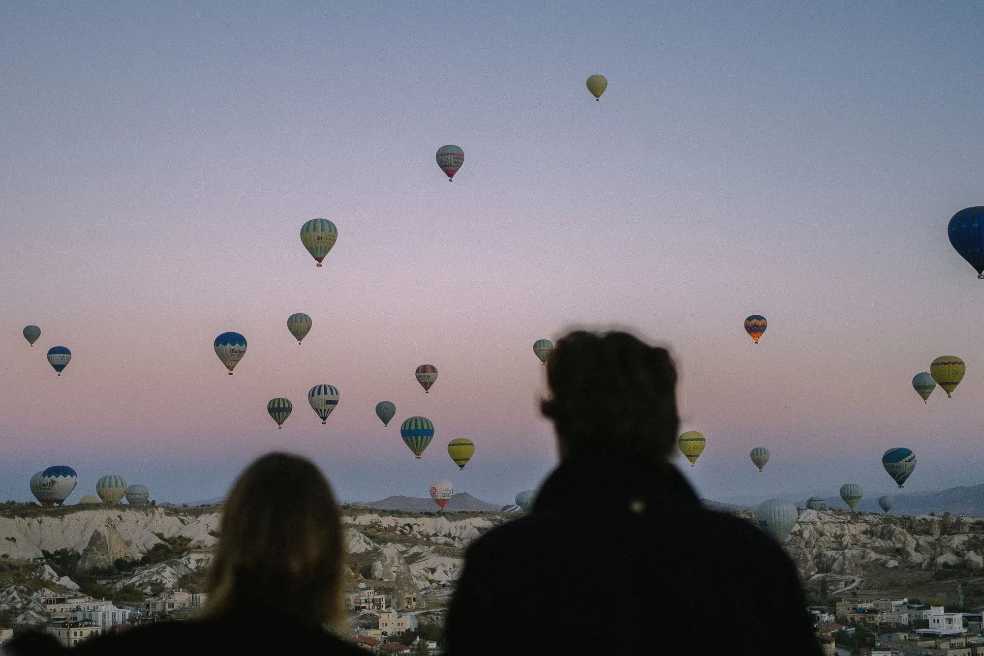 Kapadokya balon turu — şafak vakti peribacaları üzerinde sıcak hava balonları